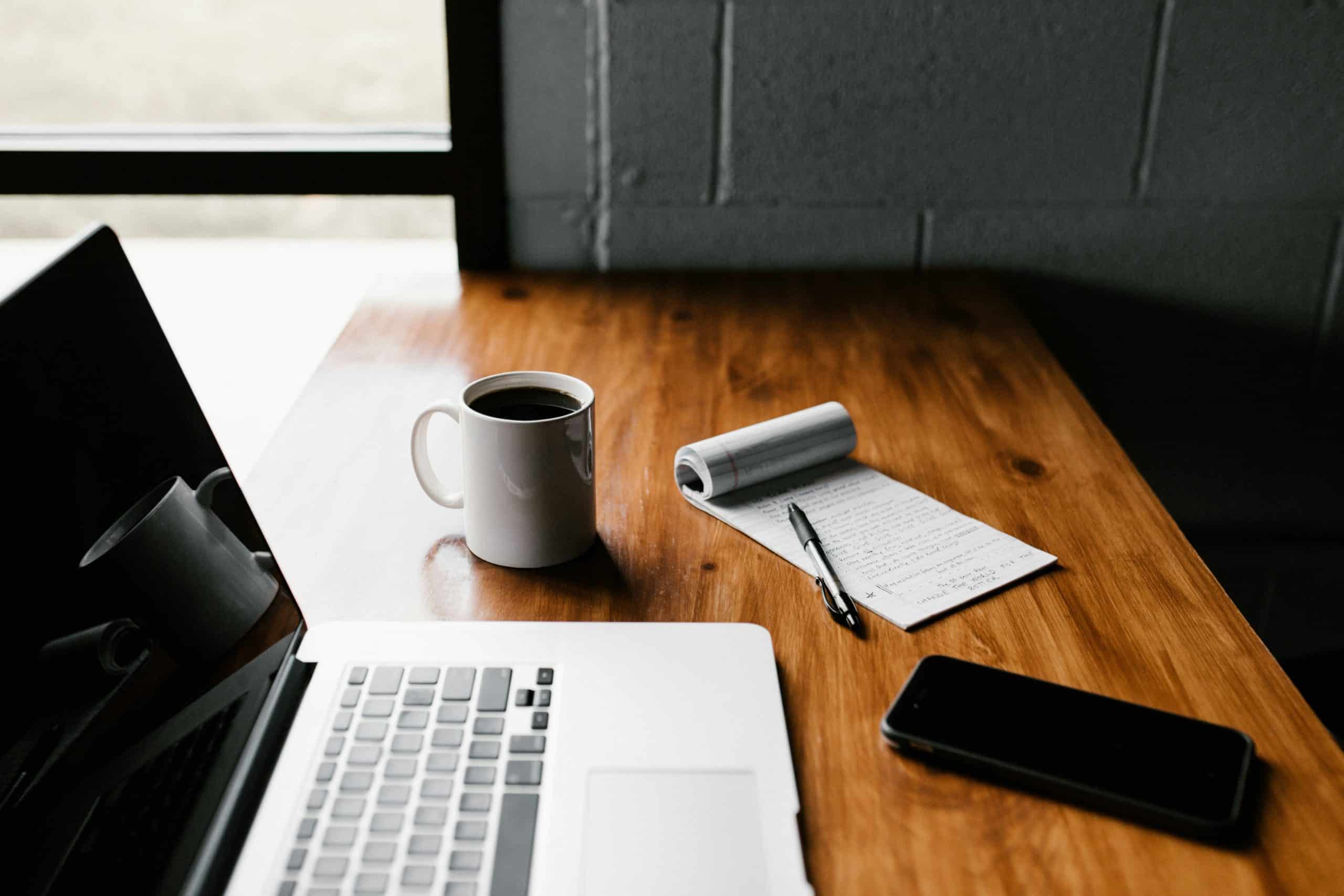 Laptop on a desk with a cup of coffee waiting to instruct Find UK People for a legal claim trace request - Legal claim tracing article
